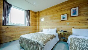 A room with two beds, wooden walls, a window with curtains, a small table with a phone, and framed pictures on the wall. - SongYuan Hotel (Lugu)