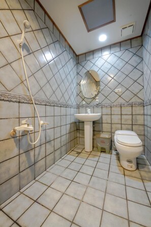 A small bathroom with a shower, sink, and toilet. - SongYuan Hotel (Lugu)