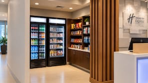 A hotel lobby with a reception desk, a Holiday Inn Express sign, and a refrigerated beverage display. - Holiday Inn Express & Suites Boise Airport by IHG (Boise)