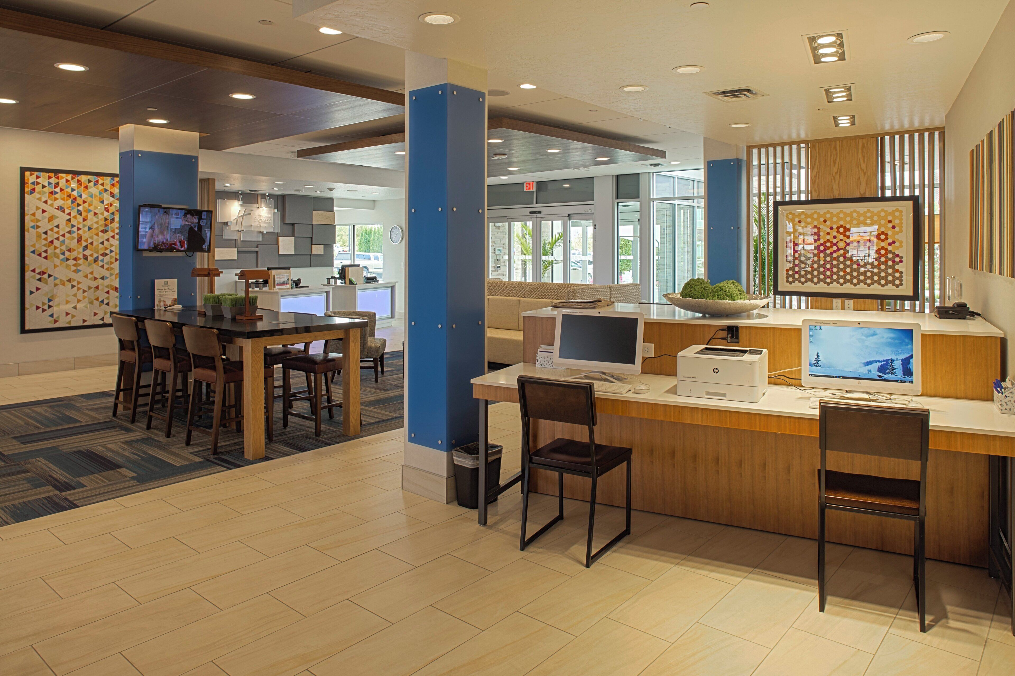 A reception area with a counter, computers, and seating.