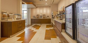 A bakery counter with various baked goods and a refrigerator displaying dairy products. - Holiday Inn Express & Suites Boise Airport by IHG (Boise)