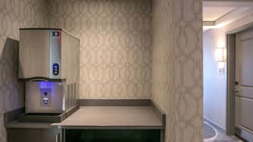 Un dispensador de agua con pantalla digital, un refrigerador pequeño y un microondas.