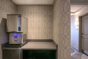 Un dispensador de agua con pantalla digital, un refrigerador pequeño y un microondas.