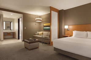 A hotel room with a large bed, a sofa, a small table, and a desk with a chair. - Hyatt Place Washington DC/Georgetown/West End (Washington)