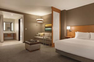 Une chambre d’hôtel avec un grand lit, un canapé, une petite table et un bureau avec une chaise.