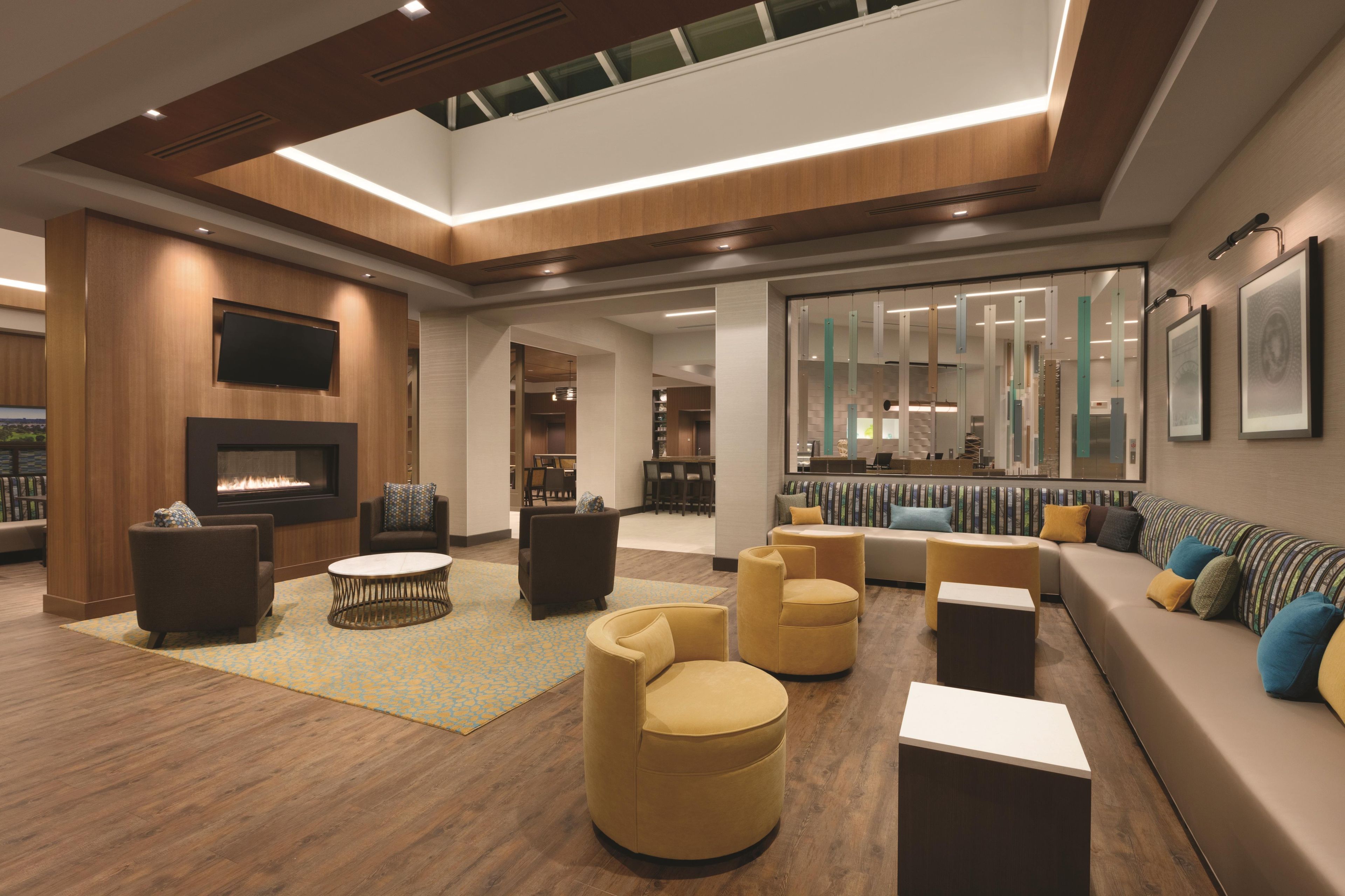A modern lounge area with a fireplace, sofas, and a coffee table.