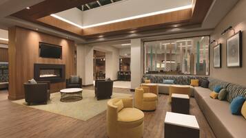 A modern lounge area with a fireplace, sofas, and a coffee table.