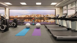 A gym with treadmills, weights, and exercise balls, featuring a large cityscape mural on the wall. - Hyatt Place Washington DC/Georgetown/West End (Washington)