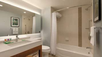 Un baño moderno con un espejo grande, una bañera, una ducha y un inodoro.