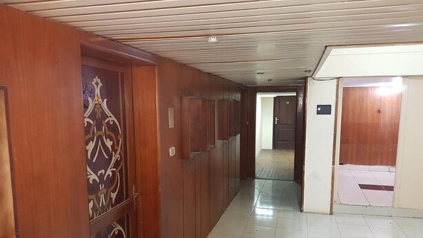 A hallway with wooden doors and a tiled floor. - Hostel Vienna (Cairo)