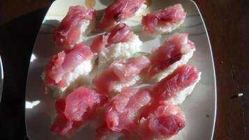 A plate of sushi with pink fish on white rice.