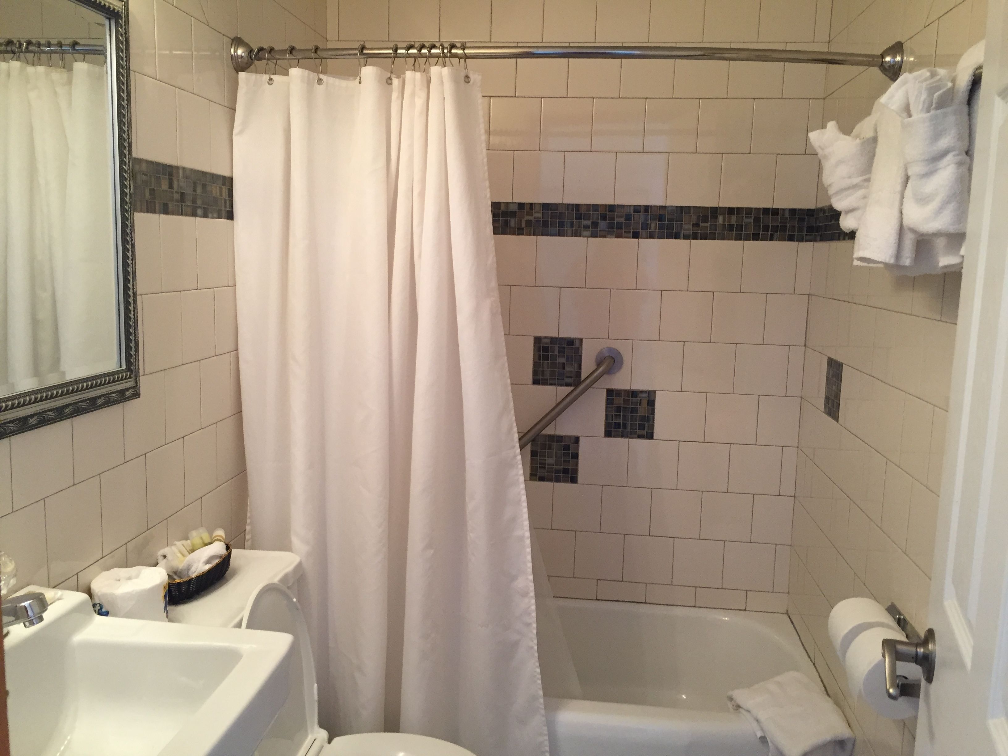 Un baño con bañera, inodoro, lavabo y cortina de ducha.