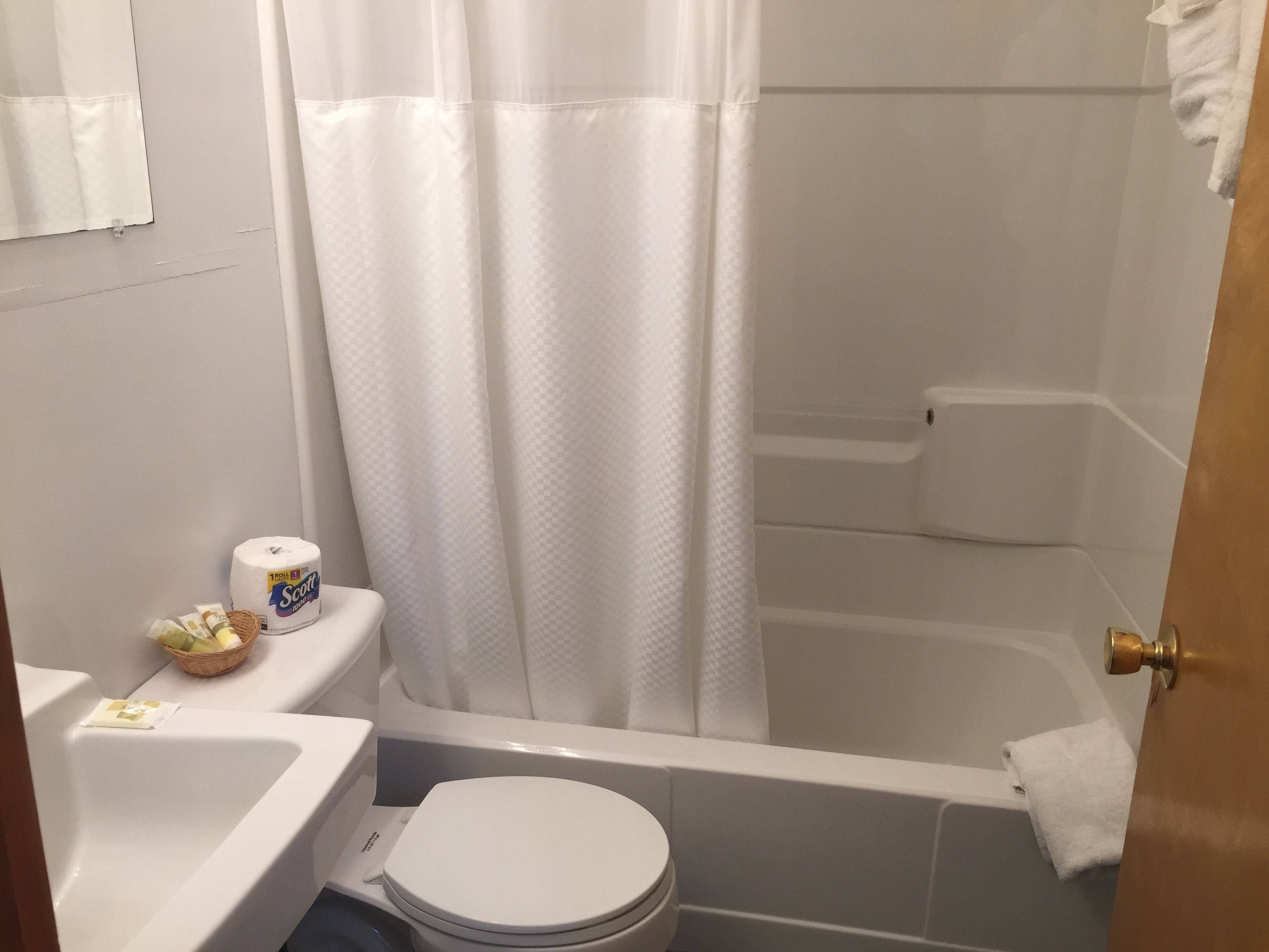 A bathroom with a toilet, sink, and bathtub.