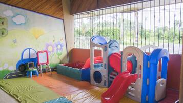 Children can play safely in this enclosed area featuring a slide, climbing wall, and playhouse.