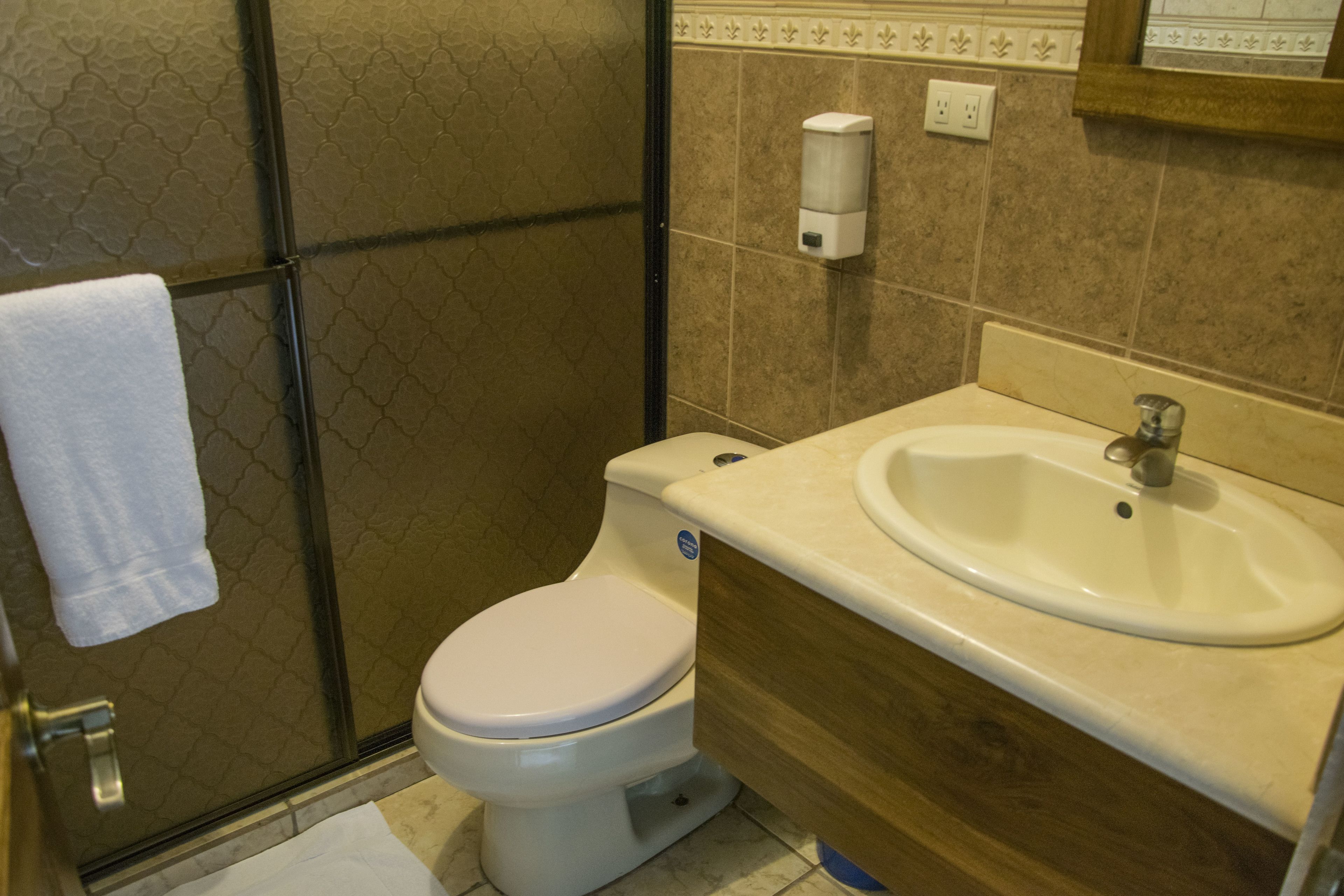 Ein Badezimmer mit Toilette, Waschbecken und Handtrockner.