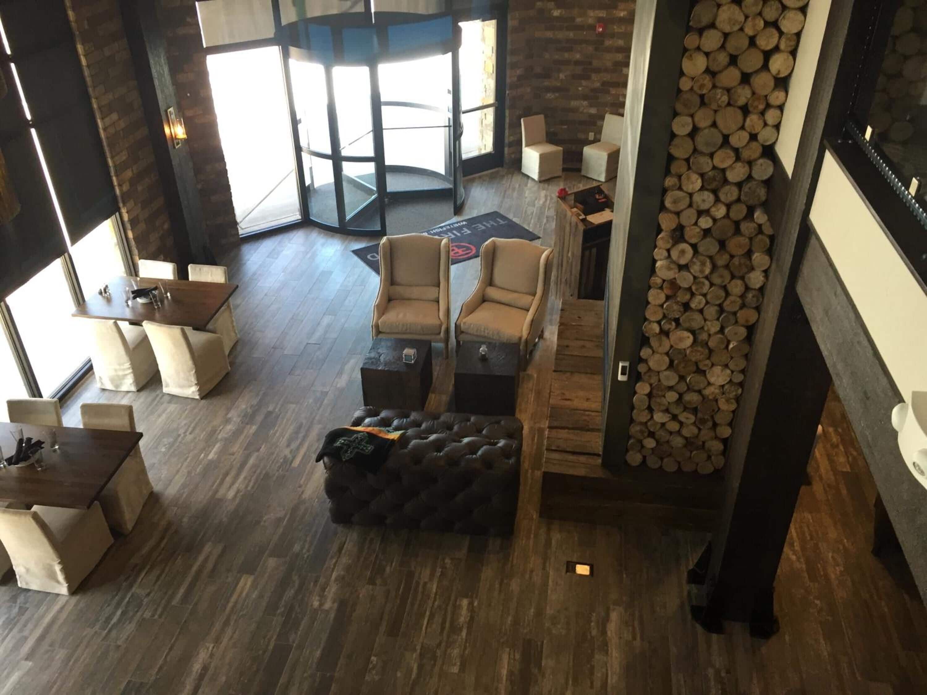 A modern interior with a central seating area, a fireplace, and a view of the outside.