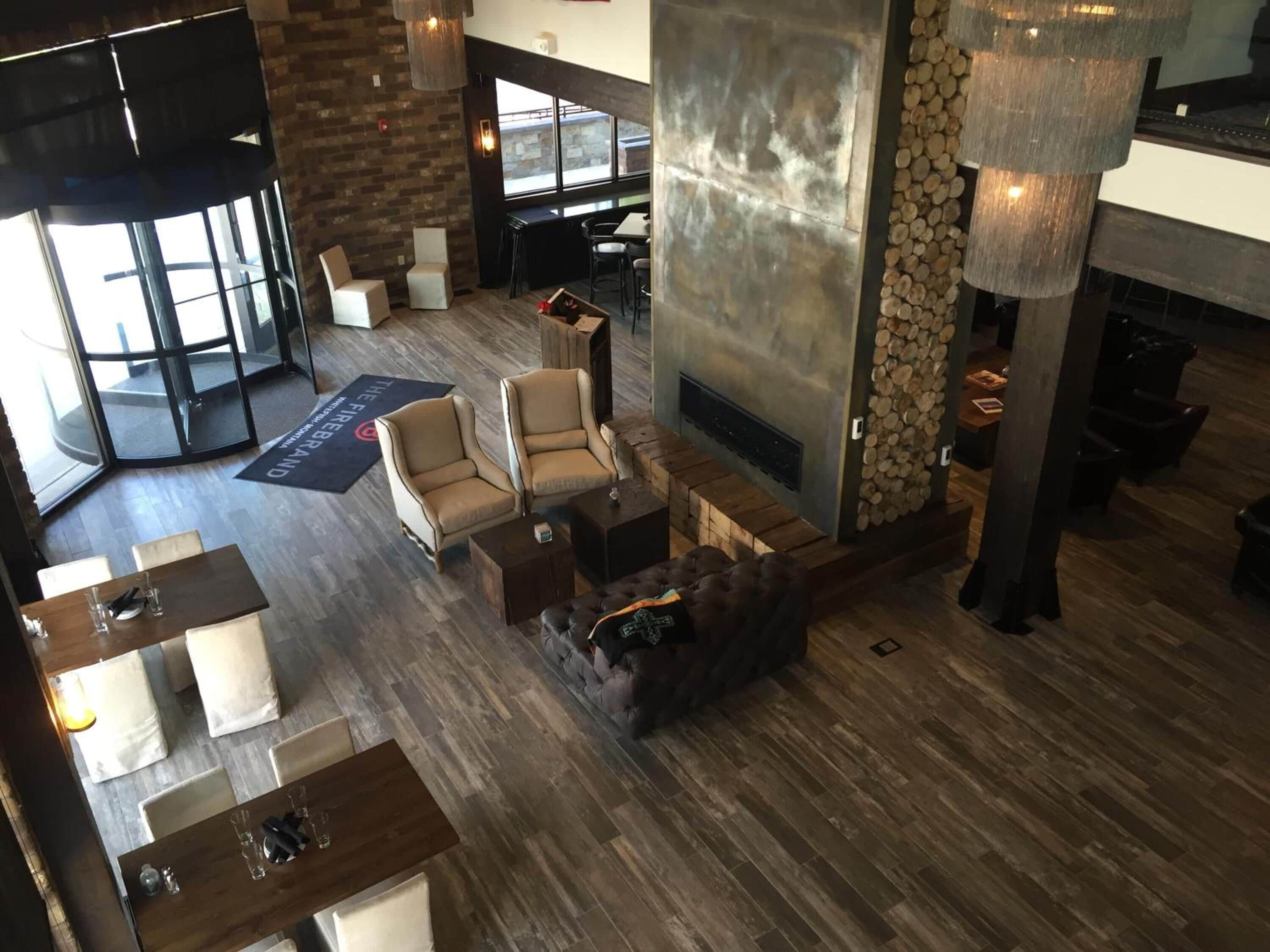 A spacious lobby with a fireplace, seating area, and a view of the outside.