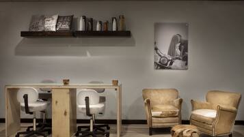 A modern office space with a desk, two chairs, a wooden coffee table, and a decorative sculpture.