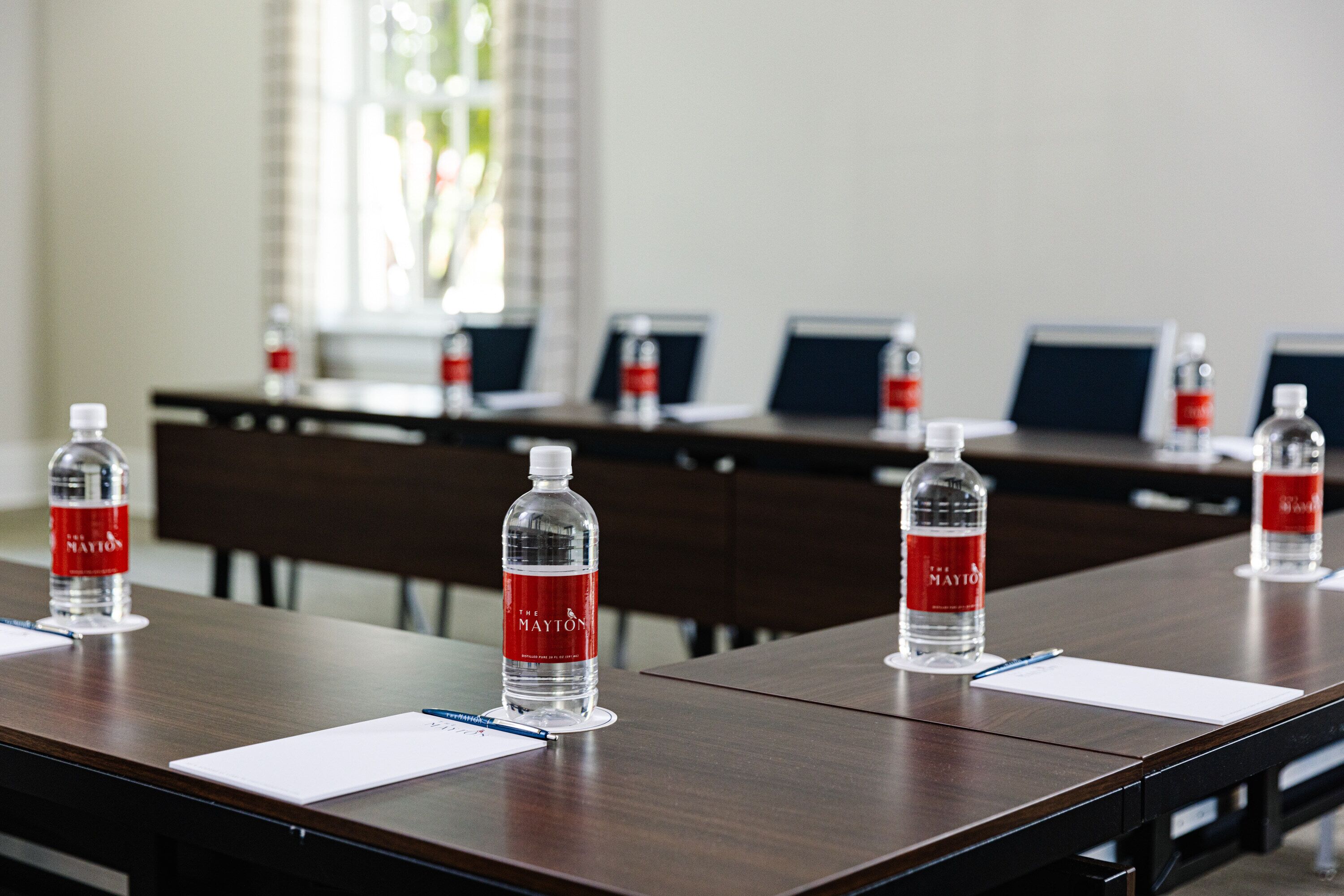 A conference room with a long table, water bottles, and nameplates.