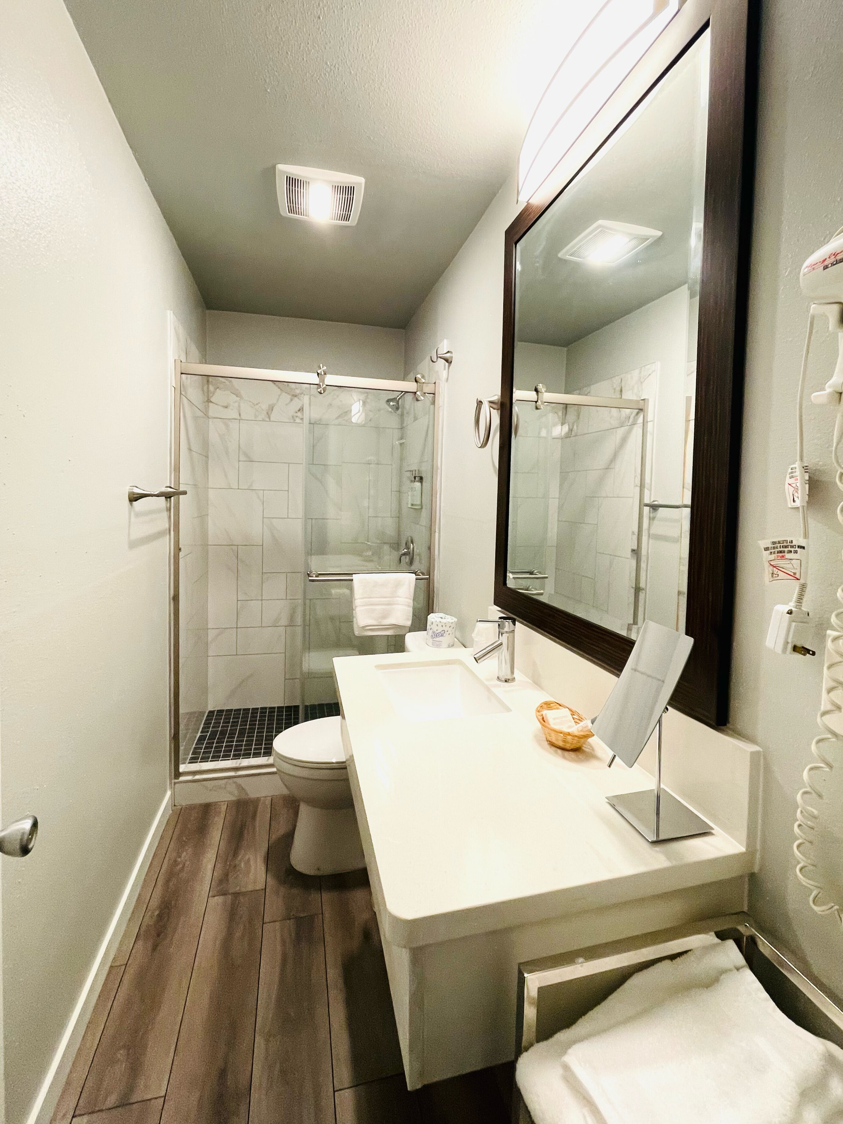 A modern bathroom with a shower, toilet, and sink.