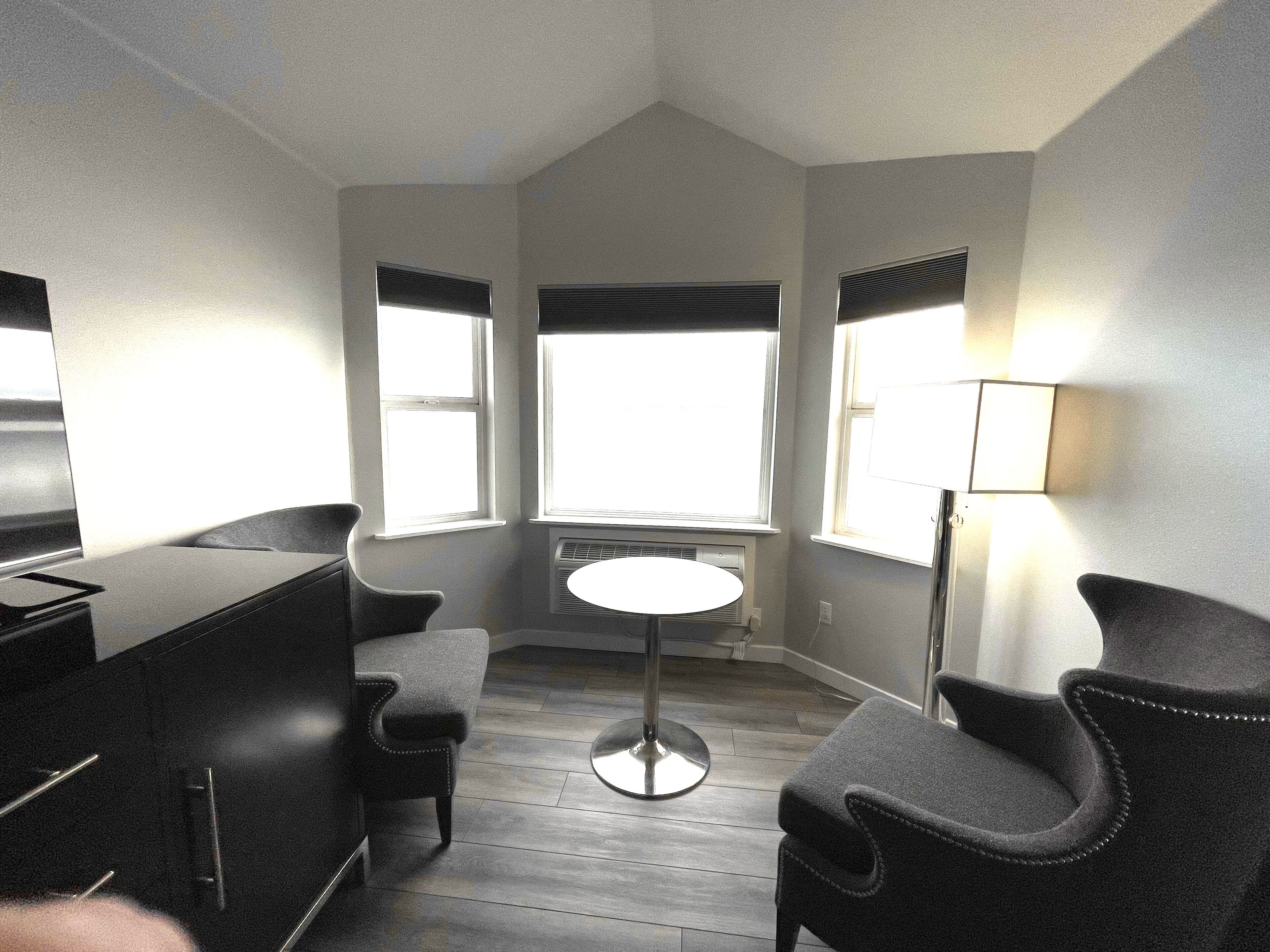 A compact kitchen with a dining area, a central island, and a window providing natural light.