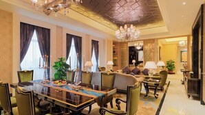 A spacious dining area with a large table and chairs, a chandelier, and a modern ceiling design. - Wanda Realm Zengcheng Guangzhou (GUANGZHOU)