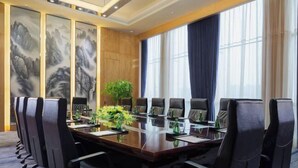 A conference room with a long table, black chairs, and a large window with curtains. - Wanda Realm Zengcheng Guangzhou (GUANGZHOU)