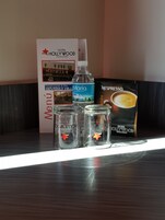 Un espace d’accueil d’hôtel avec un menu, une bouteille d’eau et une machine à café.