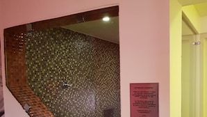 Una escalera con un muro de mosaicos y un cartel con indicaciones para los huéspedes.