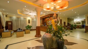 A spacious lobby with a reception desk, wicker seating, a large Buddha statue, and decorative paper lanterns. - Sovan Mealea Hotel (Siem Reap)