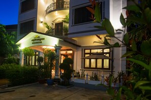 A multi-story hotel with a well-lit entrance, a covered outdoor area, and a balcony. - Sovan Mealea Hotel (Siem Reap)