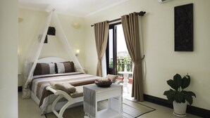A bedroom with a bed, bedside table, and a potted plant. - Sovan Mealea Hotel (Siem Reap)