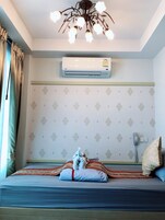Una habitación con cama, ventilador de techo, aire acondicionado y teléfono.