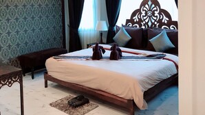 A hotel room with a bed, a desk, a chair, a lamp, and a staircase. - Namamema Boutique Hotel (Chiang Mai)