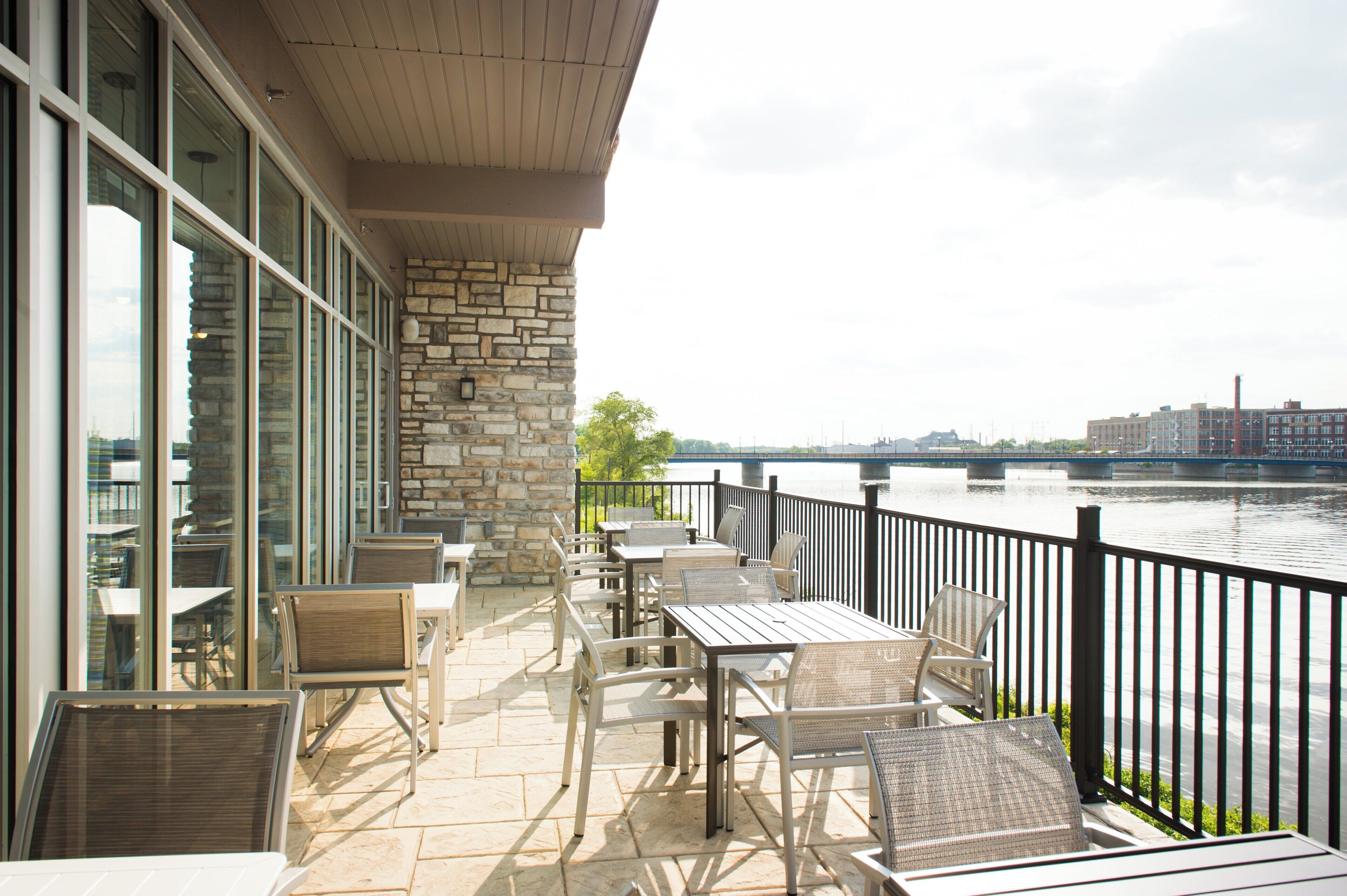A terrace with outdoor seating and a view of a river.