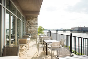Una terraza con mesas al aire libre y vistas de un río.