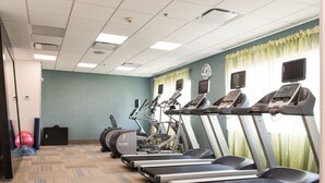 Une salle de remise en forme équipée de tapis de course, de vélos elliptiques et de ballons d’exercice.