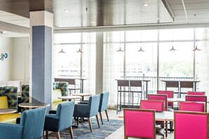 A modern hotel lobby with seating areas, large windows, and pendant lighting. - Holiday Inn Express & Suites Rock Falls by IHG (Rock Falls)