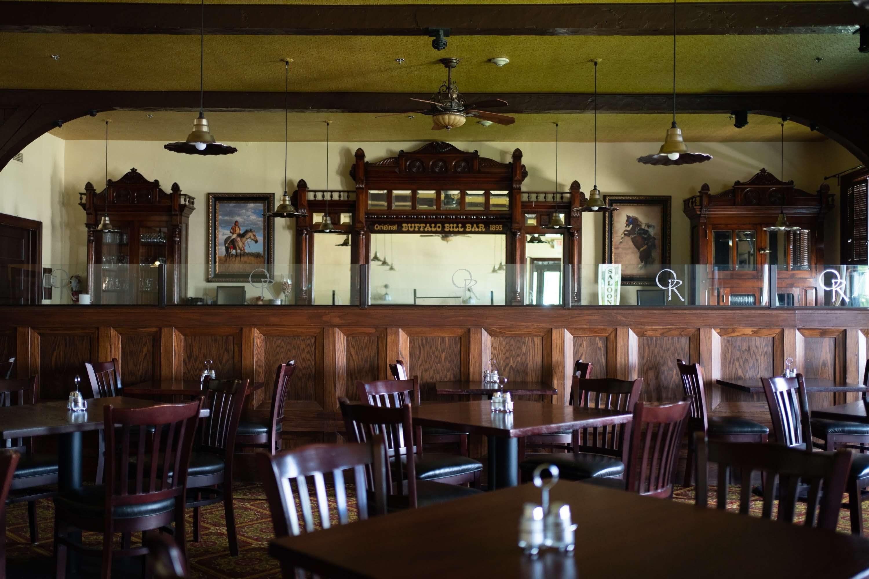 A restaurant interior with wooden booths, a bar area, and a vintage sign.