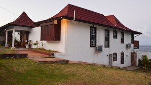 Una casa de dos pisos con techo rojo y paredes blancas.