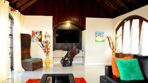 Una sala de estar con chimenea, televisor, sofá y sillón.