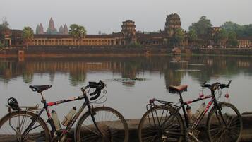 A view of Angkor Wat temple complex with two bicycles parked by the water.