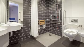 A modern bathroom with two sinks, a shower, and a toilet.