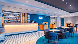 A modern hotel lobby with a bar area, seating, and a check-in counter. - Holiday Inn Express St. Albans - M25, Jct.22 by IHG (St Albans)