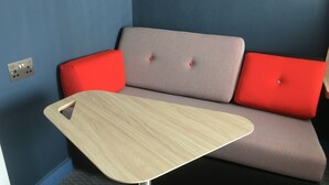 A modern room with a grey sofa, red cushions, and a wooden table. - Holiday Inn Express St. Albans - M25, Jct.22 by IHG (St Albans)