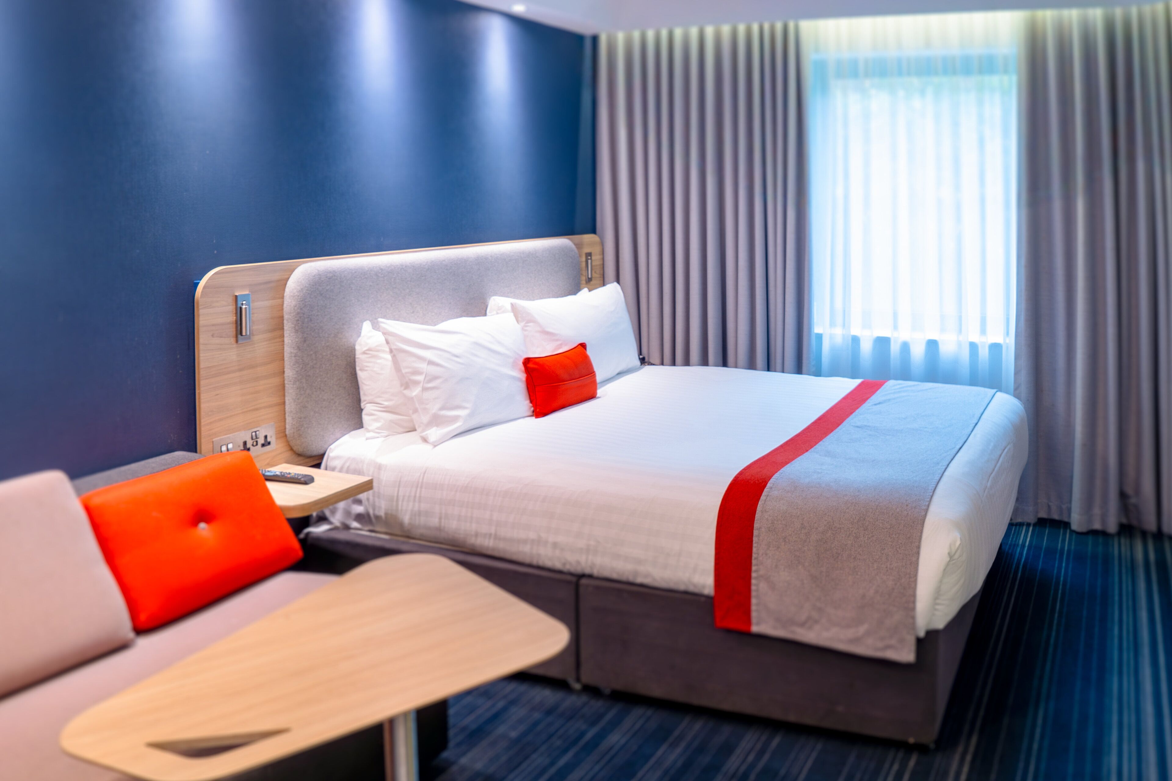 A hotel room with a bed, a desk, and a chair.