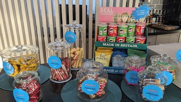 A snack display with various types of snacks and drinks, including Pringles and other brands, priced at 2.50€.