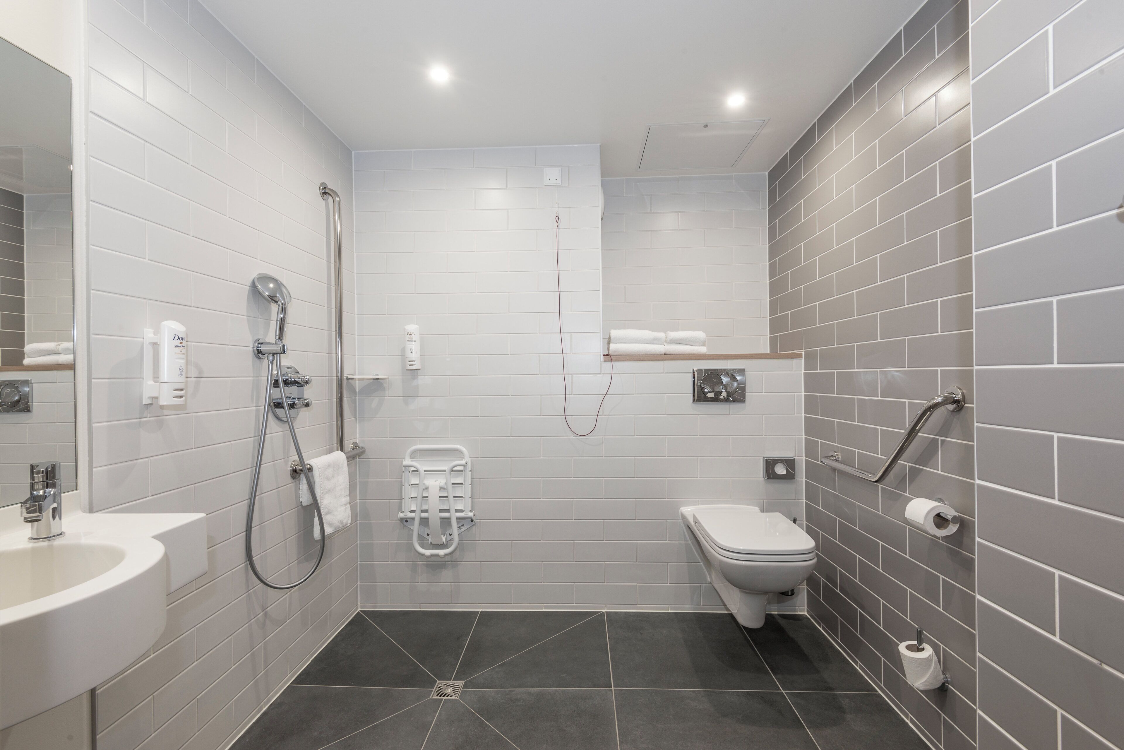 A modern bathroom with a shower, toilet, and sink.