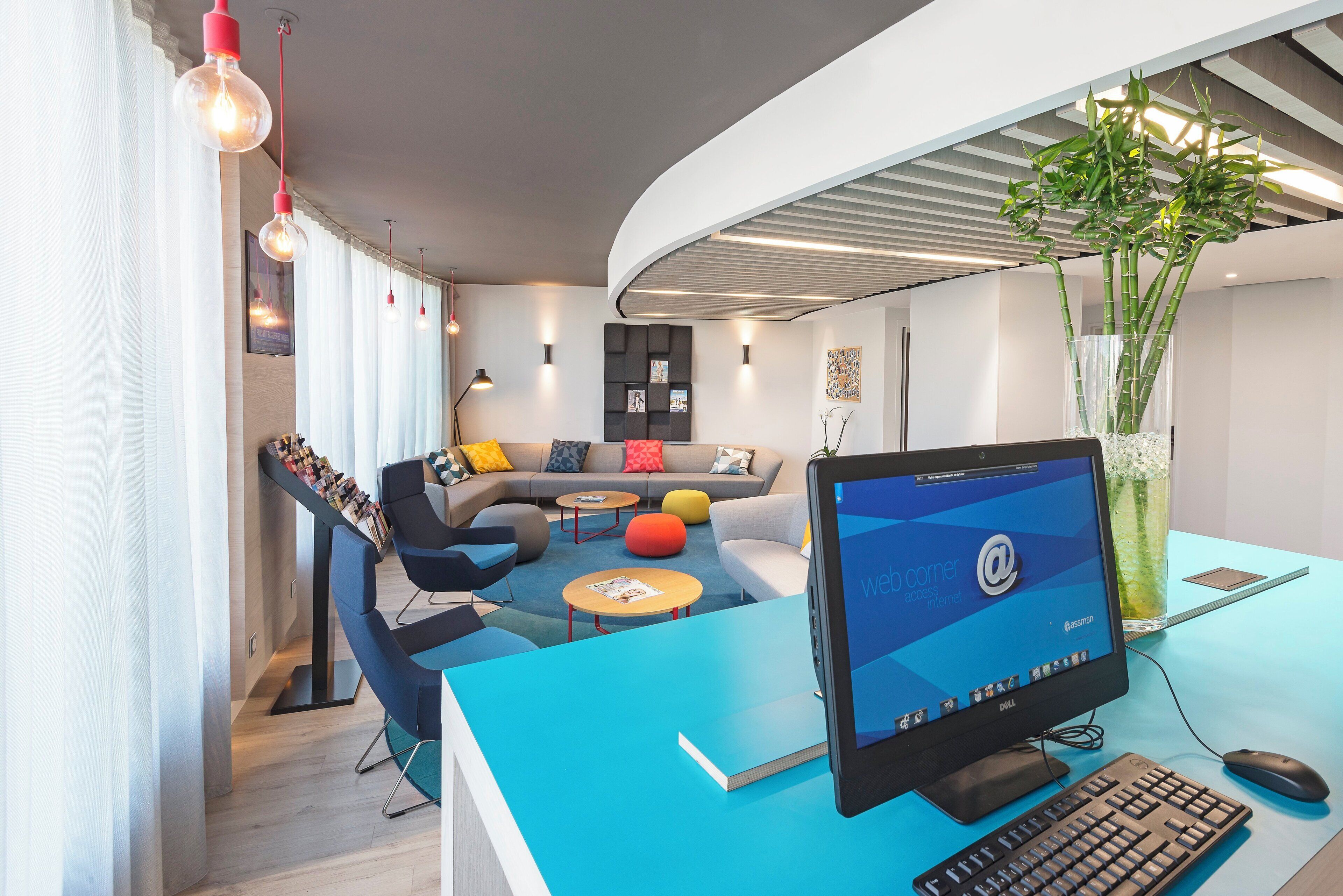 Un espace de bureau moderne avec un bureau incurvé, un ordinateur et un grand écran affichant un site web.