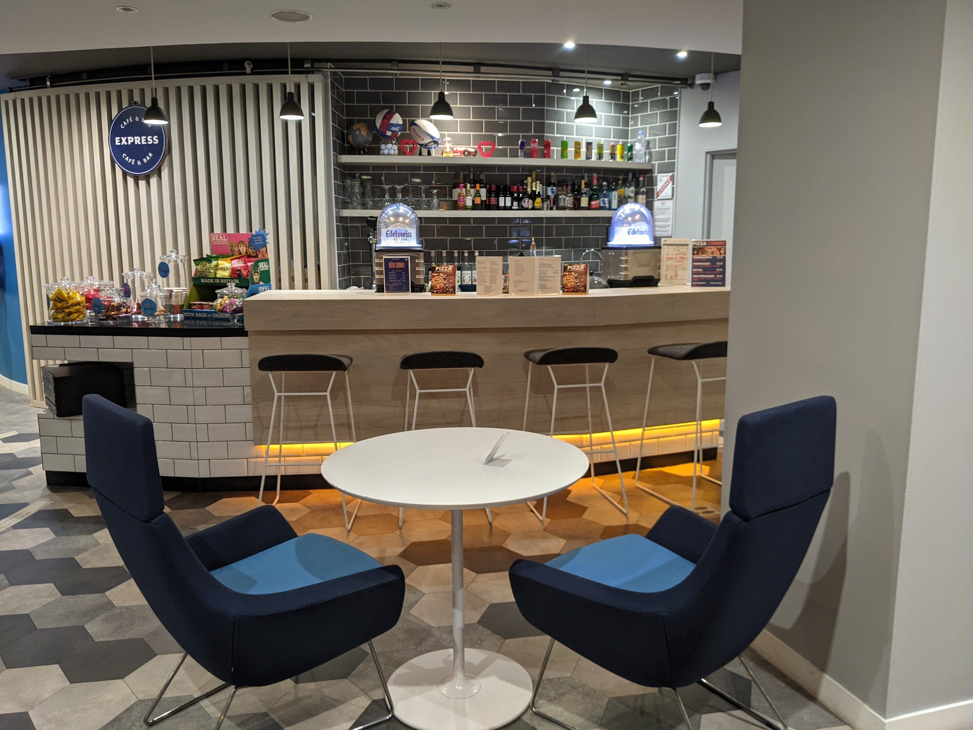 A bar area with a counter, stools, and a table.